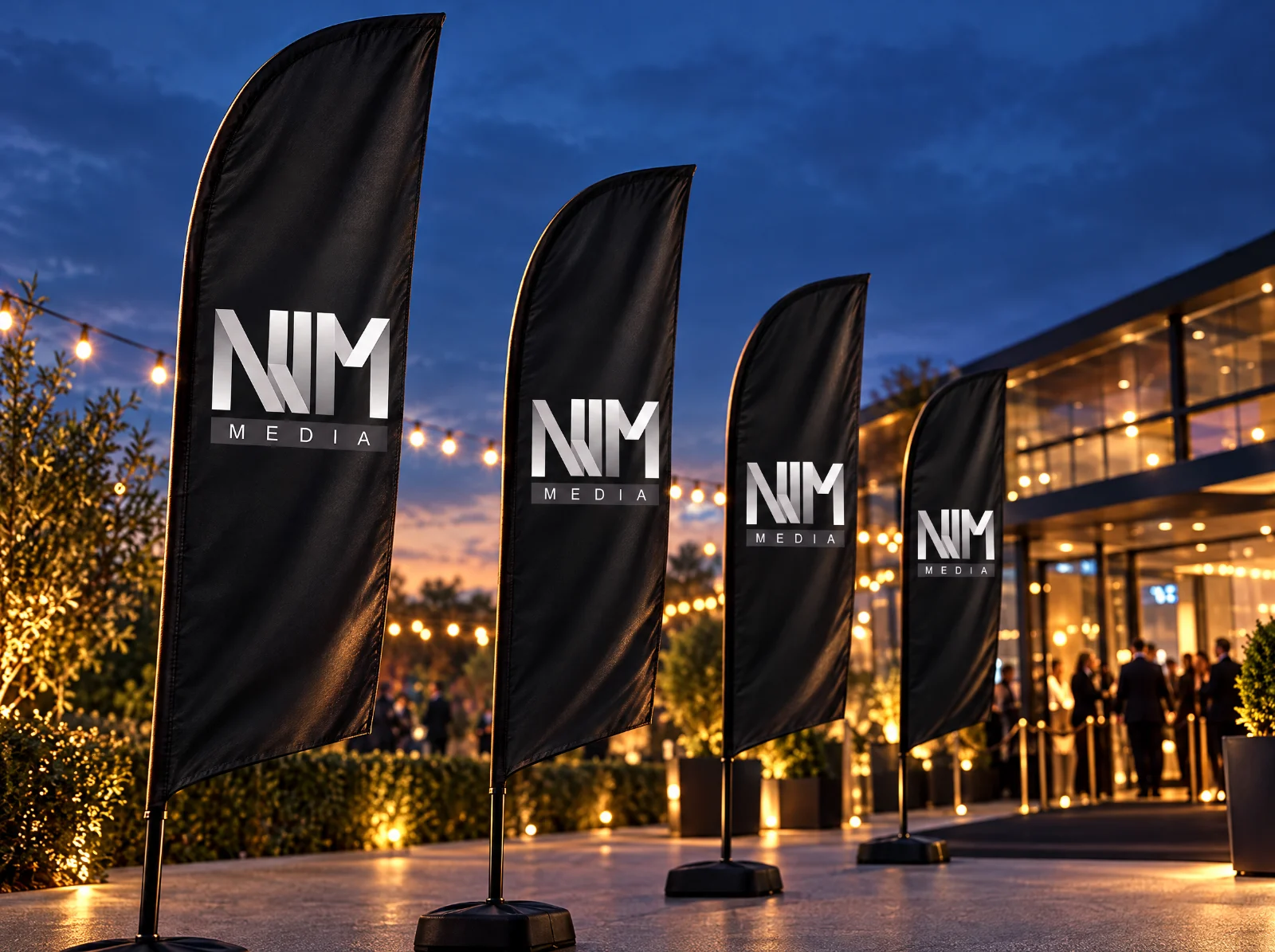 Zwarte beachflags met NJM Media-logo bij een avondevent